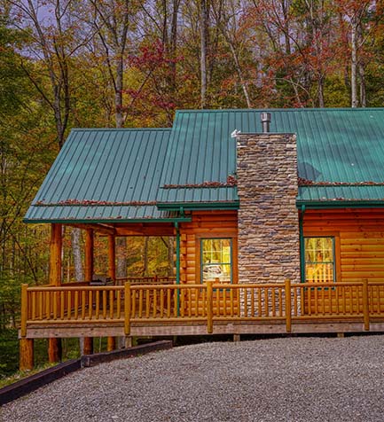 side view of log cabin, gravel drive